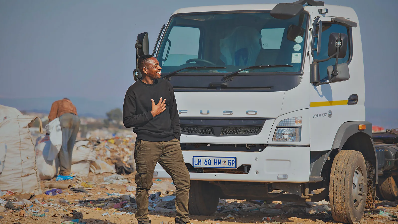 A Murero crew member alongside the hook-lift truck out on a round.